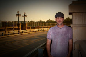 Image of author D.J. Williams standing on a bridge