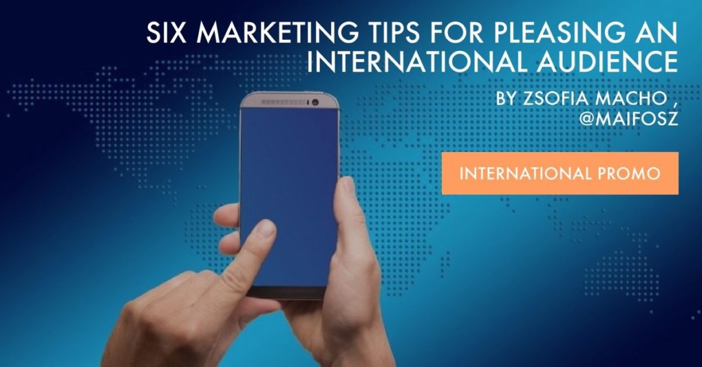 Man's hands hold a cell in front of a digital map of the world, while the post title, "6 Marketing Tips for Pleasing an International Audience by Zsofia Macho is superimposed on the top.